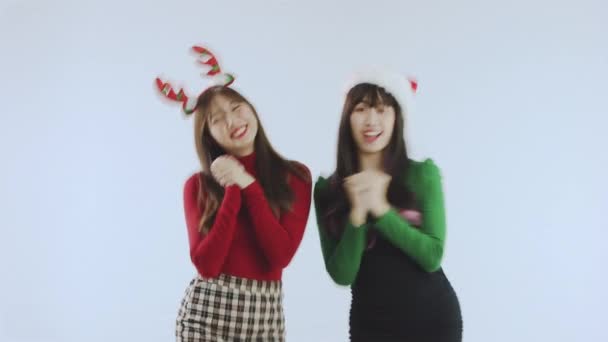 圣诞节的概念 两个快乐的亚洲女人在白色的背景工作室里独自跳着有趣的表达孤独的舞 新年快乐假日快乐 — 图库视频影像