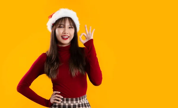 赤い長袖の若いアジアの女性 シャツは黄色の背景に をポーズ笑顔 メリークリスマステーマ — ストック写真
