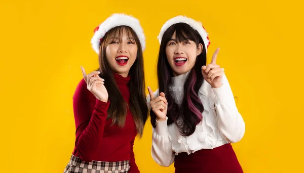 クリスマスを祝うために赤と白の色の衣装を着たアジアの女性のカップルと黄色の背景を指す新年パーティーの指 メリークリスマス — ストック写真