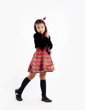 Noel temalı şirin Asyalı kız. Kameraya bakıp el pozu veriyor. Dilek beyazı bir arka plan..