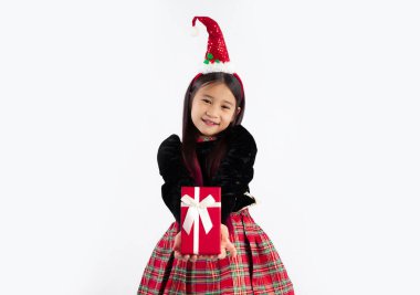 Noel temalı kostüm giymiş şirin bir kız kamera görünümlü kırmızı hediye kutusuna beyaz arka plan veriyor. Mutlu Noeller ve mutlu yıllar..