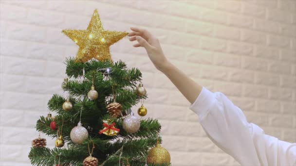 Vrouw Witte Trui Die Een Gouden Ster Aanraakt Bovenop Kerstboom — Stockvideo