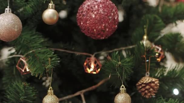 クリスマスツリーには 家族の休日のためのキラキラしたボールと球根のガーランドが飾られています 明けましておめでとうございます 縦型パンニングビデオ — ストック動画