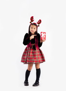 Mutlu Noeller, siyah kazaklı tatlı Asyalı kız kostüm temalı parmak işareti ve hediye kutusunu uzun beyaz arka planda tutuyor.