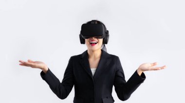 Metaverse concept, young asian businesswoman wearing vr goggles headset poising hands pointing on white background.	