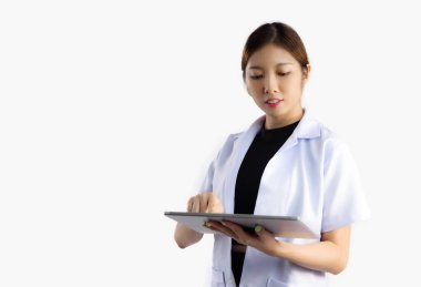 Asyalı kadın doktor tablet kullanıyor. İzliyor ve beyaz arka plana dokunuyor..