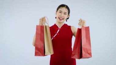 Young asian woman holding shopping bag isolated on white background Chinese New Year. 4K video footage