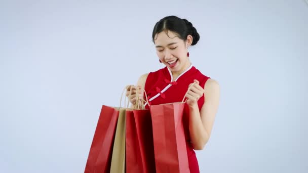 中国の旧正月を祝うために白い背景に隔離されたショッピングバッグを保持若いアジアの女性 4Kビデオ映像 — ストック動画