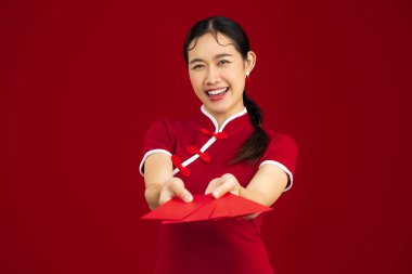 chinese new year concept, happy asian woman in red traditional chinese dress holding red envelopes.	
