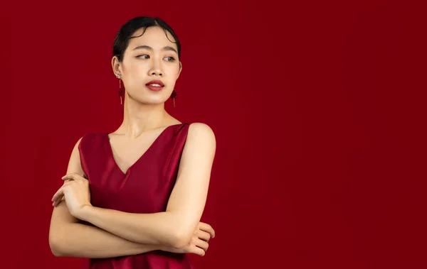 Beautiful and elegant look asian woman wear red dress posing on red color background
