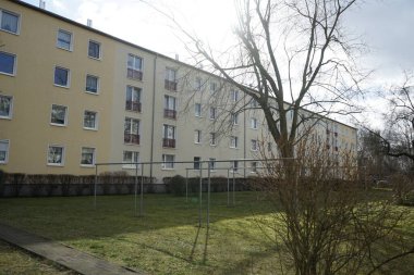 Alman Demokratik Cumhuriyeti 'nin mimarisinin bir apartmanının avlusundaki temiz havada giysileri kurutmak için metal destekler. Berlin, Almanya