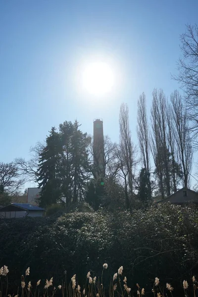 The sun over the chimney of the boiler house in March. Berlin, Germany