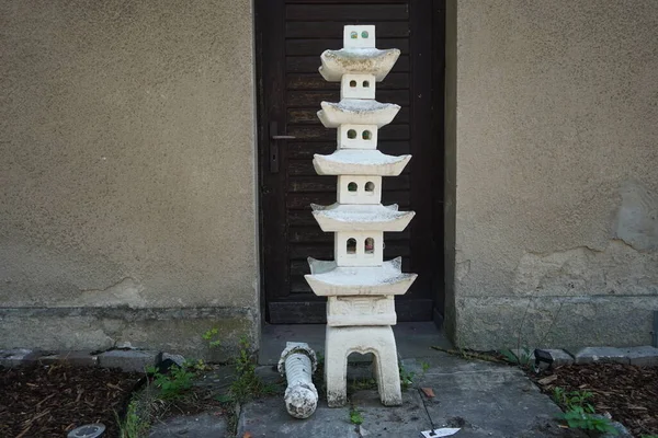 一座石制的蜡烛灯笼矗立在一座历史悠久的房子的门阶上 它是一座庄严的破顶塔 供中国或日本人的花园使用 德国柏林附近的Ruedersdorf — 图库照片