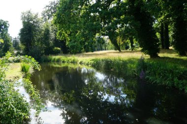 Temmuz ayında Sanssouci Parkı 'nda muhteşem bitki örtüsüyle çevrili nehir manzarası. Potsdam, Almanya 