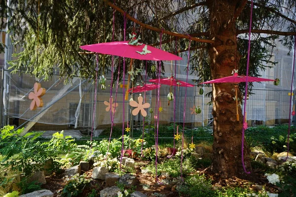 Garden decor with umbrellas, artificial flowers and butterflies. Potsdam, Germany