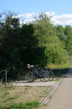 Bisikletler Ağustos 'ta Biesdorfer Baggersee gölünün kıyısındaki aksesuarda dururlar. Berlin, Almanya