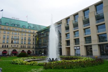 Pariser Platz 'daki tarihi çeşme Brandenburg Kapısı yakınlarındaki Berlin' in merkezinde çiçeklerle çevrili. Berlin, Almanya.