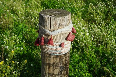Güzel örülmüş eşyalar yol boyunca tahta çit direklerini süslüyor. Berlin, Almanya 