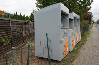 Containers for collecting old clothes and shoes are located on the street. Berlin, Germany