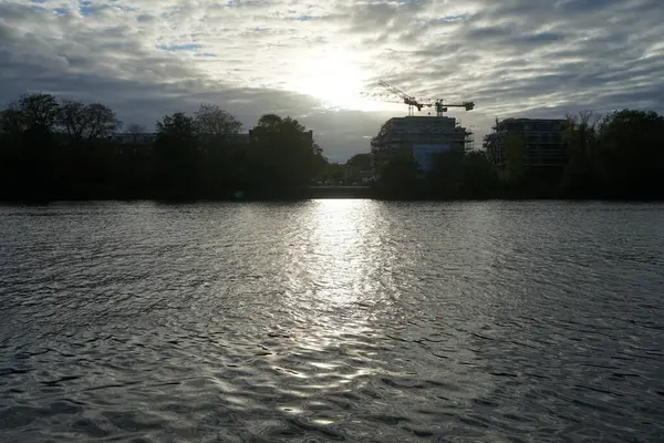 Berlin, Koepenick, Almanya - 3 Ekim 2022: Gün batımında Spree nehrinin kıyısında bir inşaat alanında çalışan bir kule vinci.