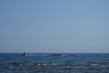 Tatilcilerin şişme su muz, su kızağı sürüşü deniz kıyısındaki tatil beldeleri için klasik bir eğlencedir. Pefki, Rodos Adası, Yunanistan   