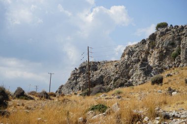 Güneşli bir günde Rodos adasının Akdeniz bitkileriyle kayalık tepelerin güzel manzarası. Rodos Adası, Yunanistan