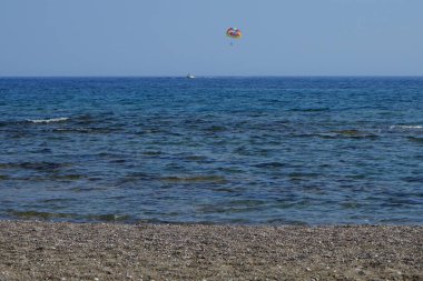 Akdeniz 'de parasailing. Parasailing (parascening), parascening (parascening), paraşütle atlama veya muhabbet kuşu, bir insanın özel olarak tasarlanmış bir kanada bağlı olarak bir aracın arkasına çekildiği eğlenceli bir uçurtma aktivitesidir. Rodos, Yunanistan 
