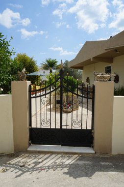 Lardos Köyü 'ndeki bahçe kapısını kurumuş dallarla süsleyen dekoratif bir vazo. Lardos, Yunanistan 'ın Güney Ege bölgesinin Rodos adasının doğu kesiminde bir Yunan köyüdür..