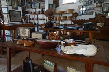 Lardos, Güney Ege bölgesi, Yunanistan - 29 Ağustos 2022: Antik müzik aletleri, fonograflar ve diğer müzik aletleri, radyo cihazları Rodos adasındaki Folklor Müzesi 'ndeki masalarda duruyor. 