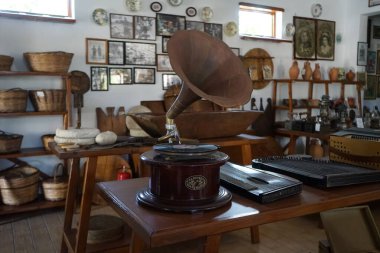 Lardos, Güney Ege bölgesi, Yunanistan - 29 Ağustos 2022: Antik müzik aletleri, fonograflar ve diğer müzik aletleri, radyo cihazları Rodos adasındaki Folklor Müzesi 'ndeki masalarda duruyor. 