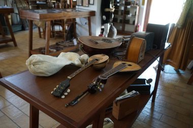 Lardos, Güney Ege bölgesi, Yunanistan - 29 Ağustos 2022: Antik müzik aletleri, fonograflar ve diğer müzik aletleri, radyo cihazları Rodos adasındaki Folklor Müzesi 'ndeki masalarda duruyor. 