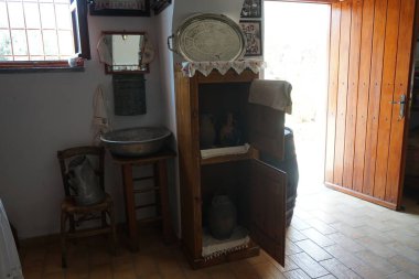 Lardos, Güney Ege bölgesi, Yunanistan - 29 Ağustos 2022: Rhodes adasındaki Folklor Müzesi 'nde ayna, havlu, lavabo ve sürahi ile yıkama istasyonu.