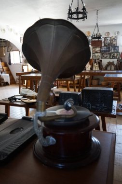 Lardos, Güney Ege bölgesi, Yunanistan - 29 Ağustos 2022: Antik müzik aletleri, fonograflar ve diğer müzik aletleri, radyo cihazları Rodos adasındaki Folklor Müzesi 'ndeki masalarda duruyor. 