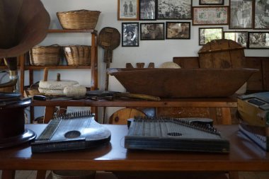 Lardos, Güney Ege bölgesi, Yunanistan - 29 Ağustos 2022: Antik müzik aletleri, fonograflar ve diğer müzik aletleri, radyo cihazları Rodos adasındaki Folklor Müzesi 'ndeki masalarda duruyor. 