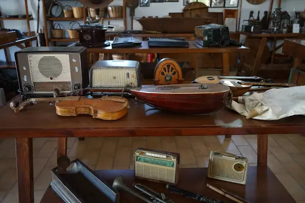 Lardos, Güney Ege bölgesi, Yunanistan - 29 Ağustos 2022: Antik müzik aletleri, fonograflar ve diğer müzik aletleri, radyo cihazları Rodos adasındaki Folklor Müzesi 'ndeki masalarda duruyor. 