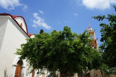 Agios Taxiarchis Ortodoks Kilisesi, meyveli narenciye ağaçlarıyla çevrilidir ve Yunanistan 'ın Rodos şehrinde bulunur. Citrus x aurantium f. aurantium, syn. Citrus x sinensis, portakalın yaygın olarak yetiştirilen bir türüdür.. 