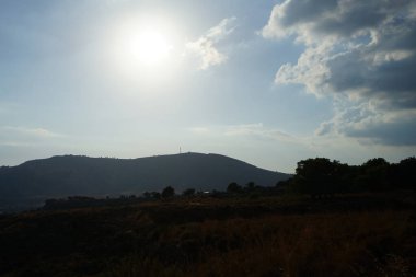 Güneş, Ağustos ayında güney Ege bölgesi Rodos Adası 'ndaki Lardos köyü civarındaki tepelerin üzerinde parlıyor
