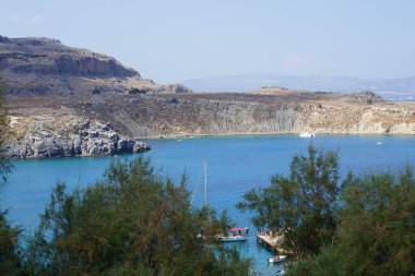 Akdeniz manzarası ve ağustosta eski Lindos kıyıları. Lindos, Yunanistan 'ın Dodecanese adasının Rodos adasında bir arkeolojik alan, bir balıkçı köyü ve eski bir belediye..