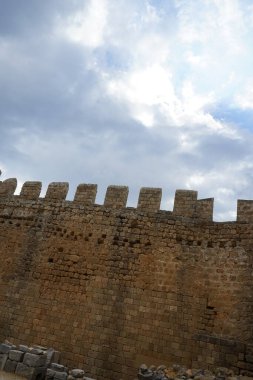 Ağustosta antik Lindos Akropolü 'ndeki kale duvarının manzarası. Bir akropolis, antik bir Yunan şehrinin üst kesimlerinin yerleşim yeriydi. Lindos, Rodos Adası, Dodecanese, Yunanistan  