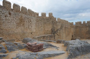 Ağustosta antik Lindos Akropolü 'ndeki kale duvarının manzarası. Bir akropolis, antik bir Yunan şehrinin üst kesimlerinin yerleşim yeriydi. Lindos, Rodos Adası, Dodecanese, Yunanistan  