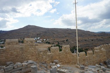 Ağustosta antik Lindos Akropolü 'ndeki kale duvarının manzarası. Bir akropolis, antik bir Yunan şehrinin üst kesimlerinin yerleşim yeriydi. Lindos, Rodos Adası, Dodecanese, Yunanistan  
