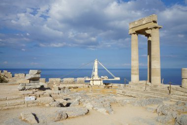 Lindos Akropolü 'ndeki Helenistik stoa' nın doğu kanadında restorasyon çalışmaları için bir vinç bulunuyor. Milattan önce 200 yılından kalma yanal projeksiyon kanatlarına sahip Helenistik stoa. Lindos, Rodos Adası, Yunanistan 