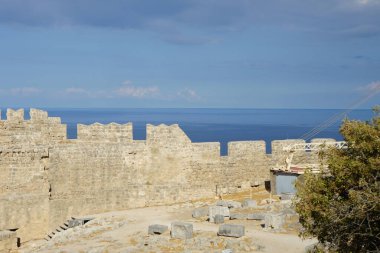 Ağustosta antik Lindos Akropolü 'ndeki kale duvarının manzarası. Bir akropolis, antik bir Yunan şehrinin üst kesimlerinin yerleşim yeriydi. Lindos, Rodos Adası, Dodecanese, Yunanistan  