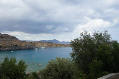 Ağustosta Lindos sahili manzarası. Lindos, Yunanistan 'ın Dodecanese kentindeki Rodos adasında bir arkeolojik alan, bir balıkçı köyü ve eski bir belediyedir.. 