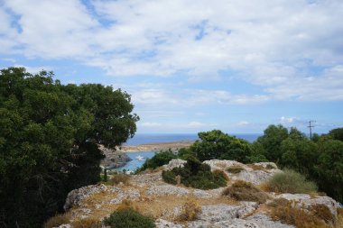 Ağustosta Lindos sahili manzarası. Lindos, Yunanistan 'ın Dodecanese kentindeki Rodos adasında bir arkeolojik alan, bir balıkçı köyü ve eski bir belediyedir.. 