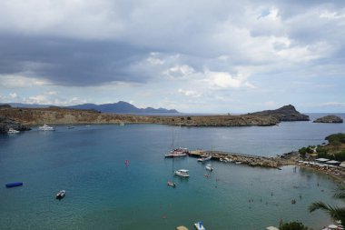 Ağustosta Lindos plajı manzarası. Lindos, Yunanistan 'ın Dodecanese kentindeki Rodos adasında bir arkeolojik alan, bir balıkçı köyü ve eski bir belediyedir..