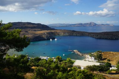 Ağustosta Lindos plajı manzarası. Lindos, Yunanistan 'ın Dodecanese kentindeki Rodos adasında bir arkeolojik alan, bir balıkçı köyü ve eski bir belediyedir..