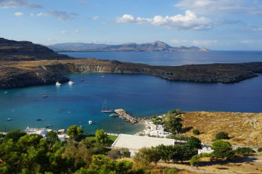 Ağustosta Lindos plajı manzarası. Lindos, Yunanistan 'ın Dodecanese kentindeki Rodos adasında bir arkeolojik alan, bir balıkçı köyü ve eski bir belediyedir..