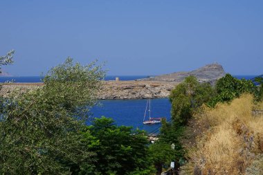 Ağustosta Lindos sahili manzarası. Lindos, Yunanistan 'ın Dodecanese kentindeki Rodos adasında bir arkeolojik alan, bir balıkçı köyü ve eski bir belediyedir.. 