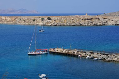 Ağustosta Lindos sahili manzarası. Lindos, Yunanistan 'ın Dodecanese kentindeki Rodos adasında bir arkeolojik alan, bir balıkçı köyü ve eski bir belediyedir.. 